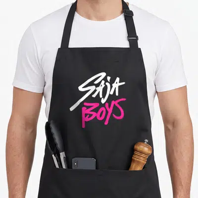 Band hunter apron - White SAJA and pink BOYS stacked typography logo design — shown on a black cotton canvas apron against a white background