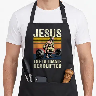 Jesus deadlifter ultimate apron - Distressed vintage graphic of Jesus deadlifting with retro striped background — shown on a black cotton canvas apron against a white background