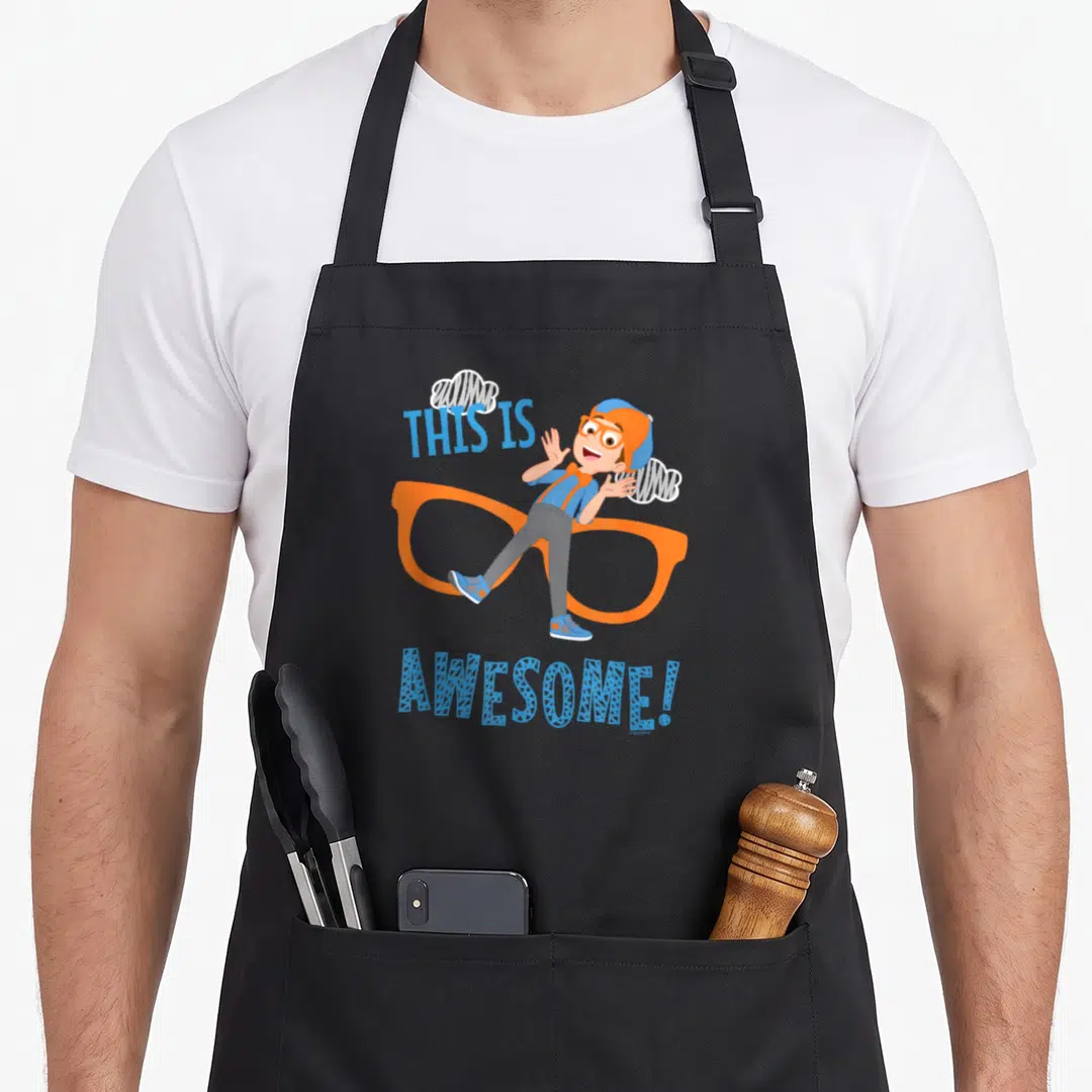 Blippi glass apron - Cartoon boy leaning on orange glasses with THIS IS AWESOME! text and white clouds — shown on a black cotton canvas apron against a white background