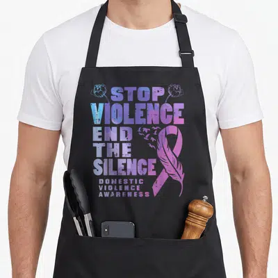 End domestic aprons - Stacked text Stop Violence End Silence with purple ribbon feather and birds — shown on a black cotton canvas apron against a white background