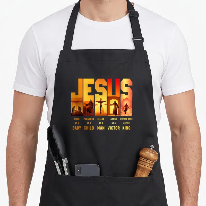 Jesus a's aprons - Orange JESUS text framing five vertical biblical scenes with descriptive captions below — shown on a black cotton canvas apron against a white background