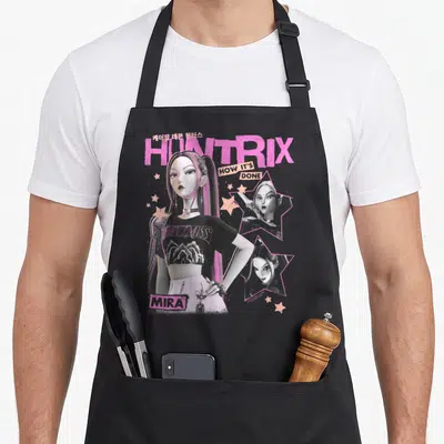 Mira y2k trend apron - Mira character art with Huntrix text and pink stars on black apron — shown on a black cotton canvas apron against a white background