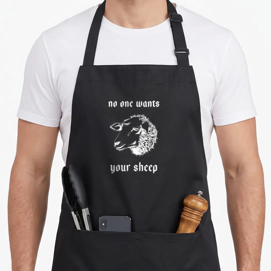 Resource sheep apron - White line art sheep head between text no one wants your sheep on black fabric — shown on a black cotton canvas apron against a white background