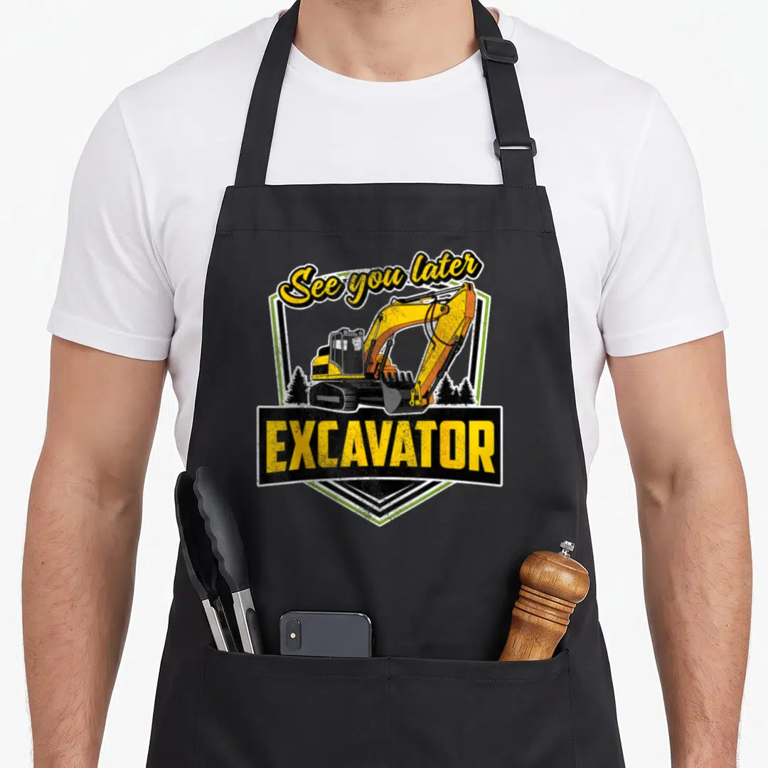 See heavy apron - Retro shield with yellow excavator and See you later EXCAVATOR text — shown on a black cotton canvas apron against a white background