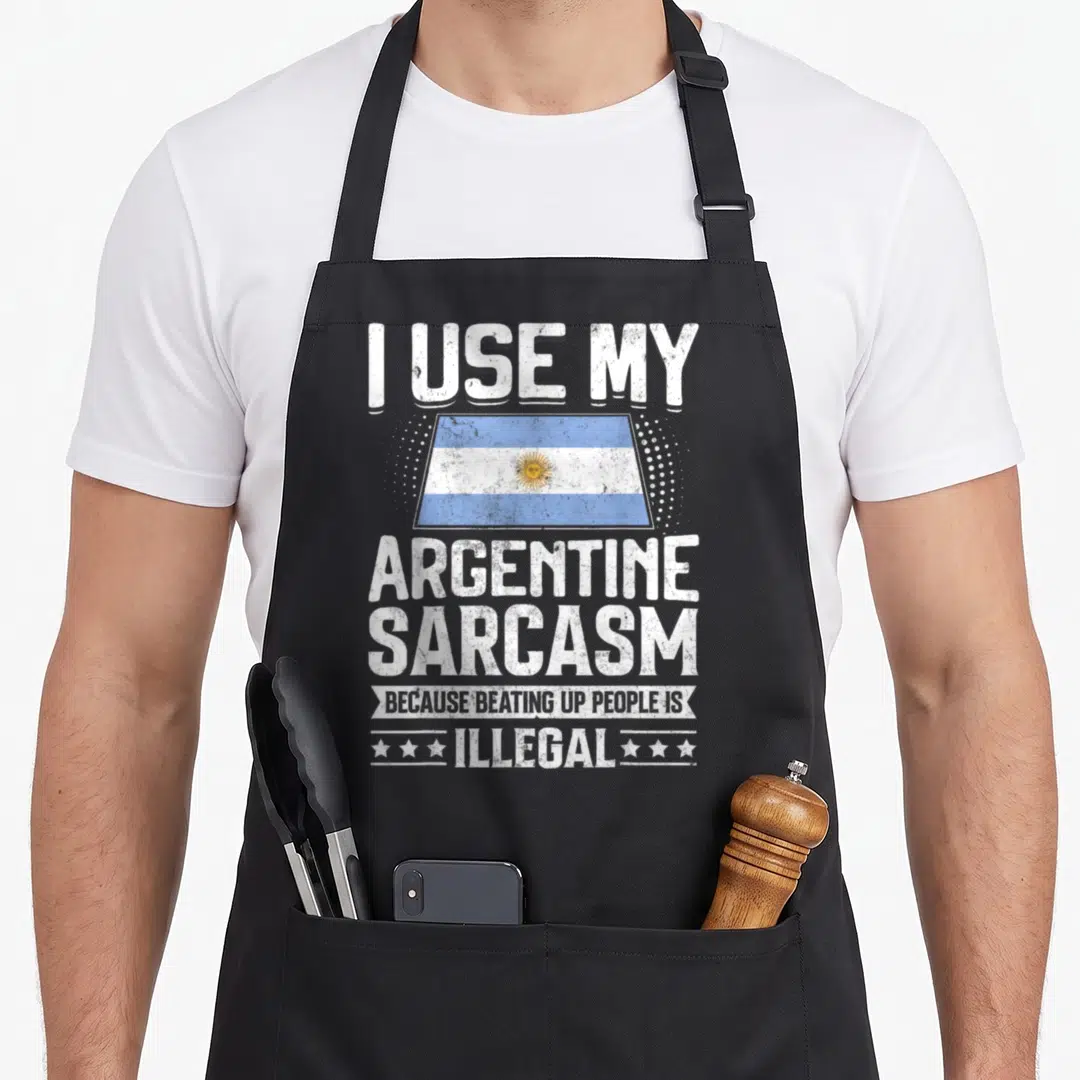 Souvenir argentine apron - Distressed flag and text I USE MY ARGENTINE SARCASM BECAUSE BEATING UP PEOPLE IS ILLEGAL — shown on a black cotton canvas apron against a white background