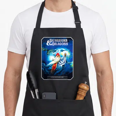 Advanced dungeon apron - Wizard in red hood casting blue magic surrounded by dragons with DUNGEONS DRAGONS text — shown on a black cotton canvas apron against a white background