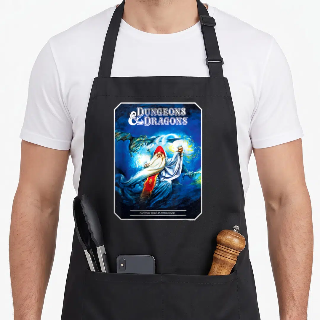 Advanced dungeon apron - Wizard in red hood casting blue magic surrounded by dragons with DUNGEONS DRAGONS text — shown on a black cotton canvas apron against a white background