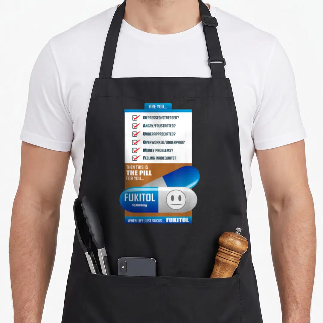 Fukitol physician apron - Checklist of stressed feelings and large blue white pill labeled Fukitol 10,000mg — shown on a black cotton canvas apron against a white background
