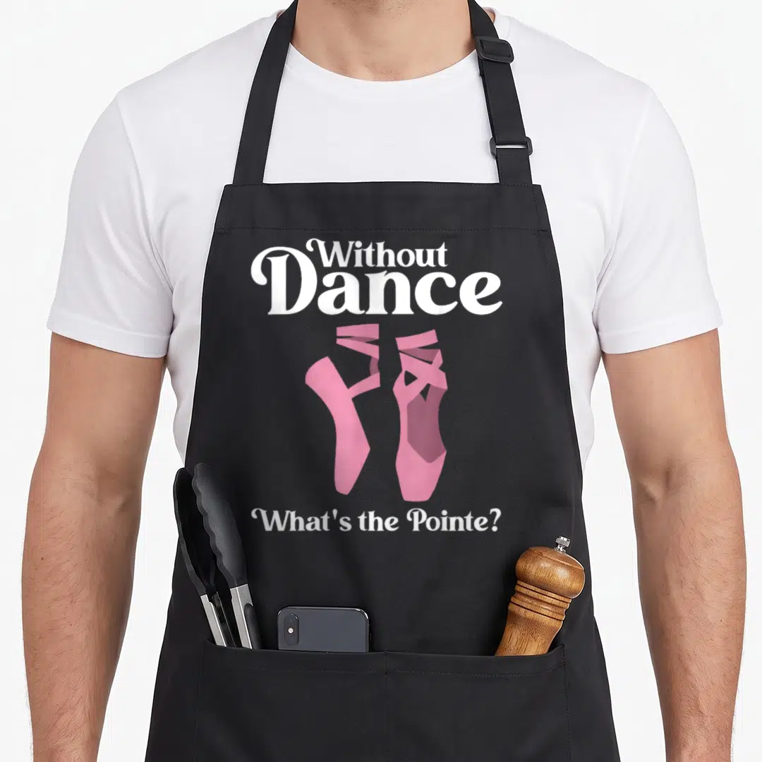 Pointe ballerina apron - White text reading Without Dance What's the Pointe above a pair of pink ballet shoes — shown on a black cotton canvas apron against a white background