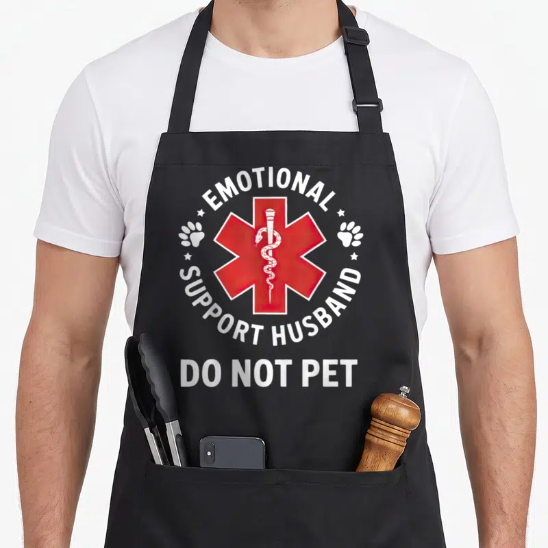 Funny emotional husband apron - Red Star of Life with Rod of Asclepius and white DO NOT PET text surrounded by paw — shown on a black cotton canvas apron against a white background