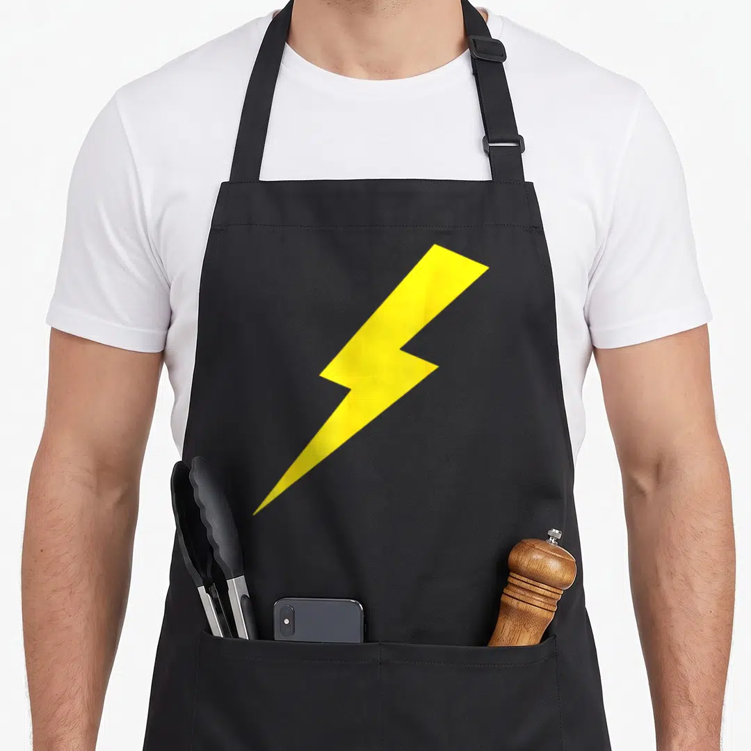 Cute lightning lighting bolt apron - Single yellow lightning bolt centered on black fabric background — shown on a black cotton canvas apron against a white background