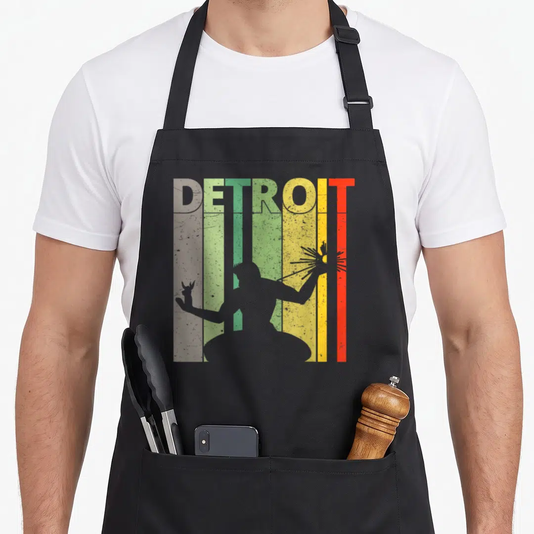 Funny detroit apron - Grey person silhouette holding deer and sunburst against five colored vertical stripes — shown on a black cotton canvas apron against a white background