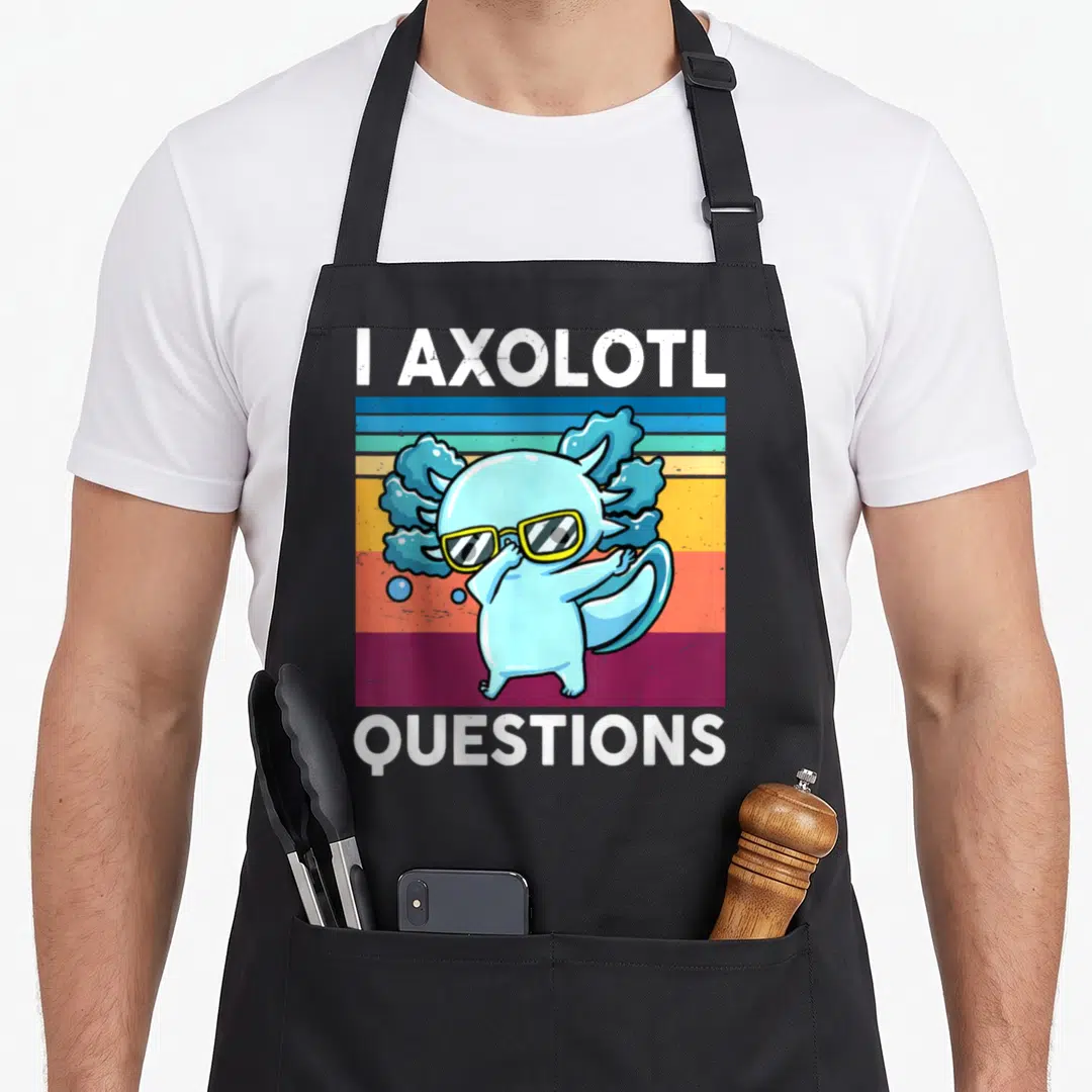 Question salamander apron - Blue axolotl wearing yellow glasses on striped background with text I AXOLOTL QUESTIONS — shown on a black cotton canvas apron against a white background
