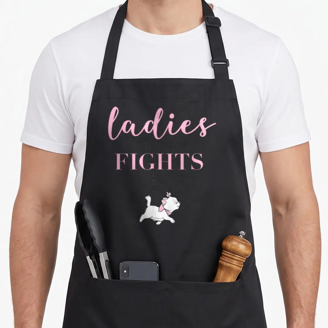 Aristocat novelty apron - Cartoon white cat with pink bow below pink and grey text saying ladies don't start fights — shown on a black cotton canvas apron against a white background