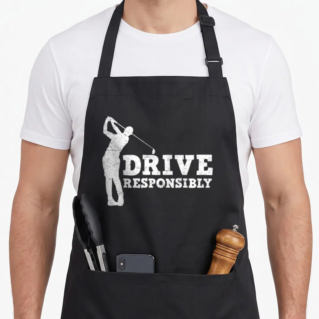 Drive golf apron - Distressed white golfer swinging next to stacked text DRIVE RESPONSIBLY — shown on a black cotton canvas apron against a white background