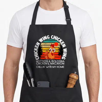 Chicken hot dog apron - Retro cartoon chicken in sunset circle surrounded by viral song lyrics in white text — shown on a black cotton canvas apron against a white background