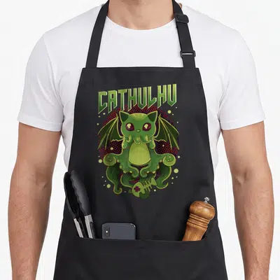 Cathulhu kawaii apron - Green Cthulhu cat on red black dotted circle with fish skeleton and arched text — shown on a black cotton canvas apron against a white background