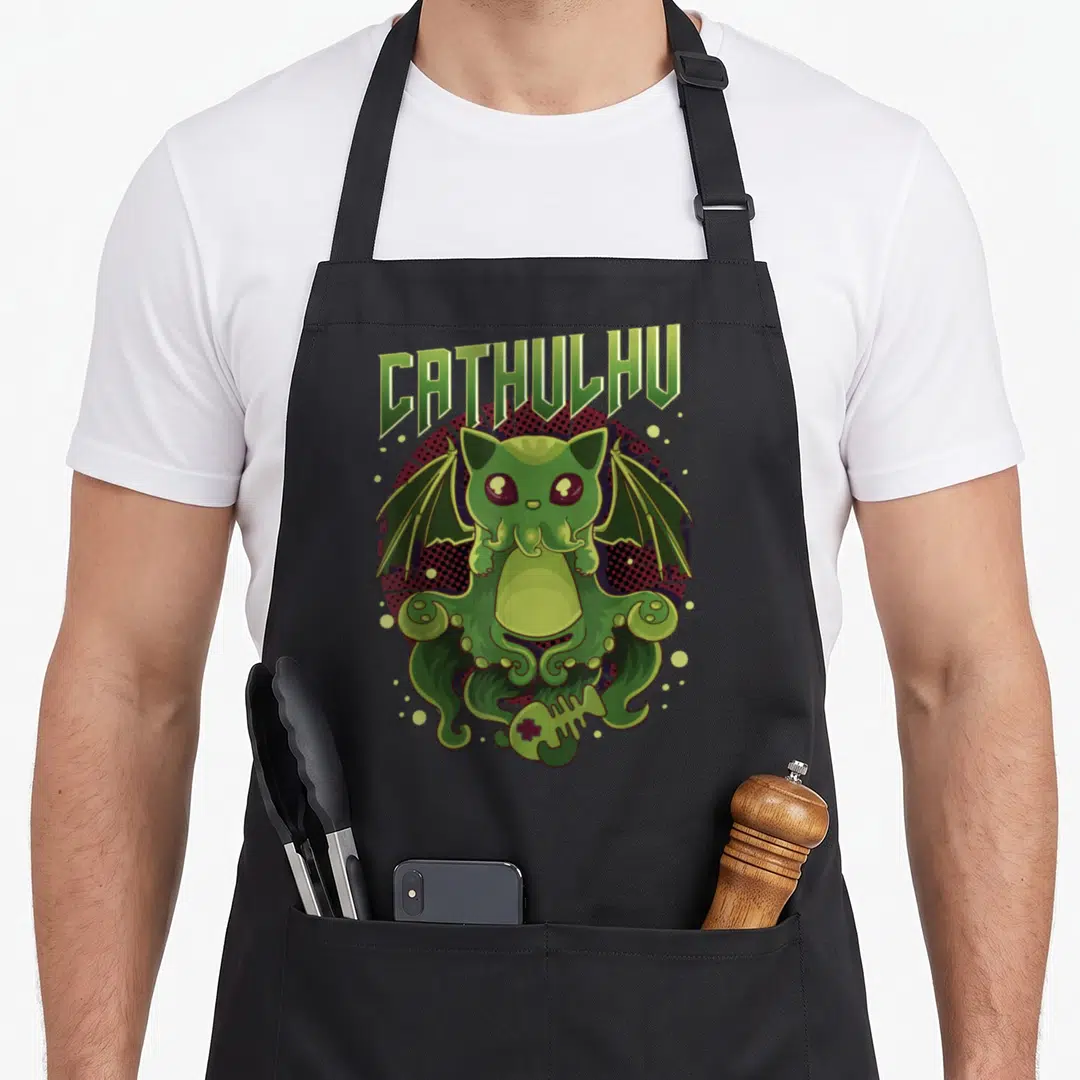 Cathulhu kawaii apron - Green Cthulhu cat on red black dotted circle with fish skeleton and arched text — shown on a black cotton canvas apron against a white background