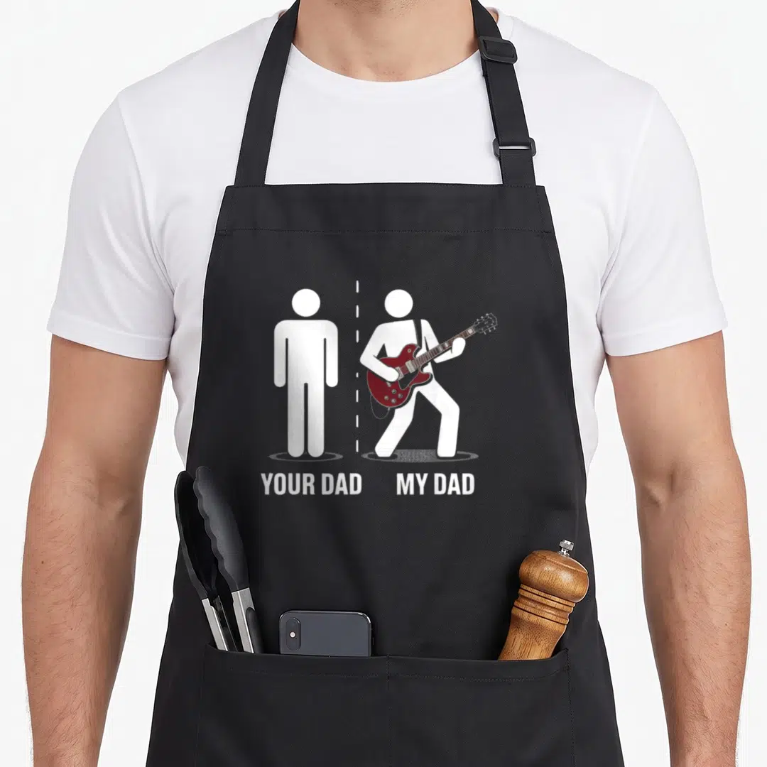 Father music dad apron - Two white stick figures separated by dashed line, one stands still, other plays maroon guitar — shown on a black cotton canvas apron against a white background