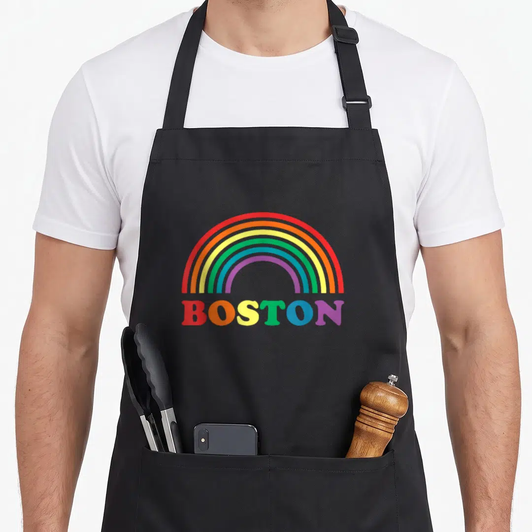 Parade gay pride apron - Rainbow arch above BOSTON text with letters in red orange yellow green blue and purple — shown on a black cotton canvas apron against a white background