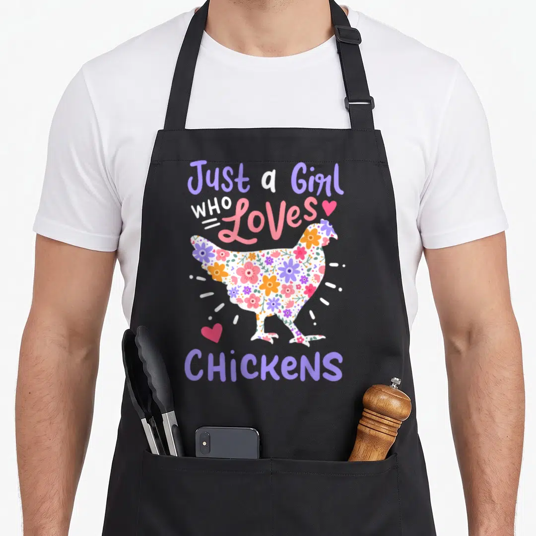 Chicken hen apron - Floral patterned chicken silhouette surrounded by purple and pink text reading Just a Girl Who — shown on a black cotton canvas apron against a white background