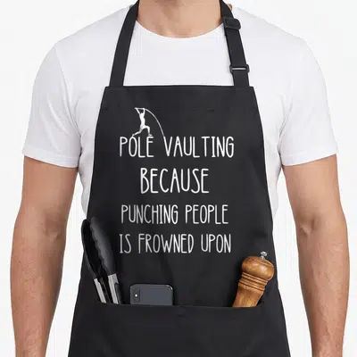 Punching vaulting apron - White pole vaulter silhouette above stacked text POLE VAULTING BECAUSE PUNCHING PEOPLE IS — shown on a black cotton canvas apron against a white background