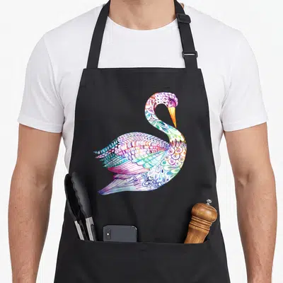 Swan colorful aprons - Multicolored watercolor swan with purple blue green pink orange feathers on black background — shown on a black cotton canvas apron against a white background