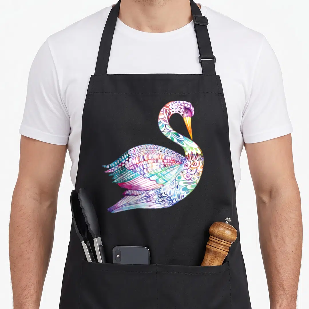 Swan colorful aprons - Multicolored watercolor swan with purple blue green pink orange feathers on black background — shown on a black cotton canvas apron against a white background