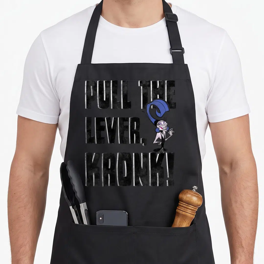 Emperor it problems apron - PULL THE LEVER KRONK text next to blue-haired cartoon character Yzma — shown on a black cotton canvas apron against a white background
