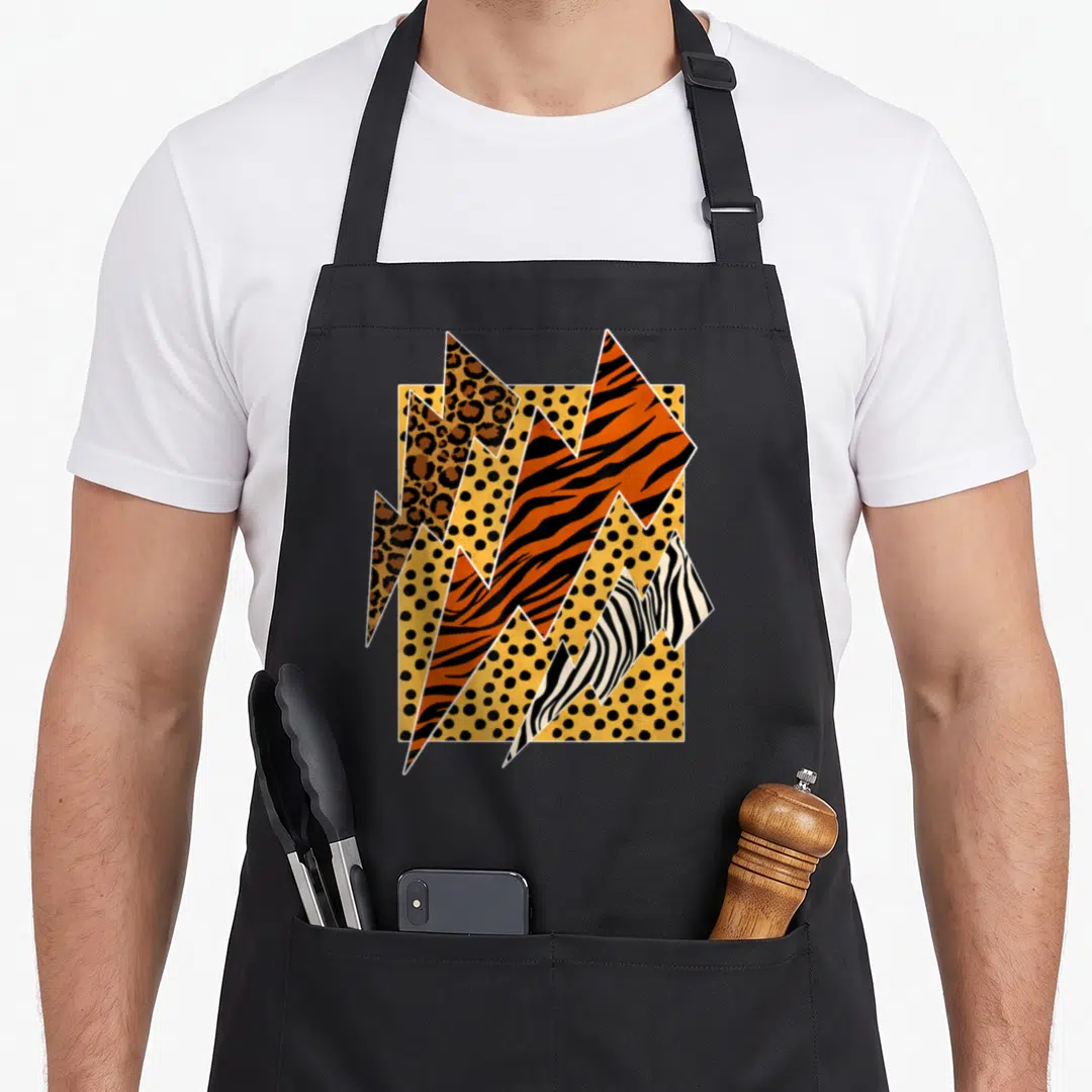 Leopard zebra apron - Retro lightning bolts with leopard tiger zebra prints on yellow polka dot background — shown on a black cotton canvas apron against a white background