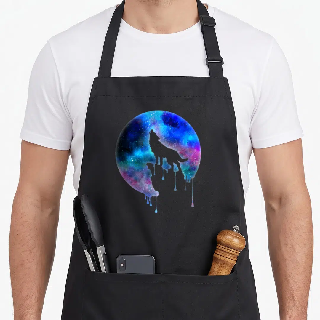 Howling moon apron - Wolf silhouette inside dripping blue purple pink watercolor circle — shown on a black cotton canvas apron against a white background