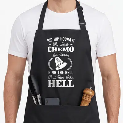 Chemo hip apron - White stacked text reading My Last Chemo Is Today with a bell and two wreaths — shown on a black cotton canvas apron against a white background