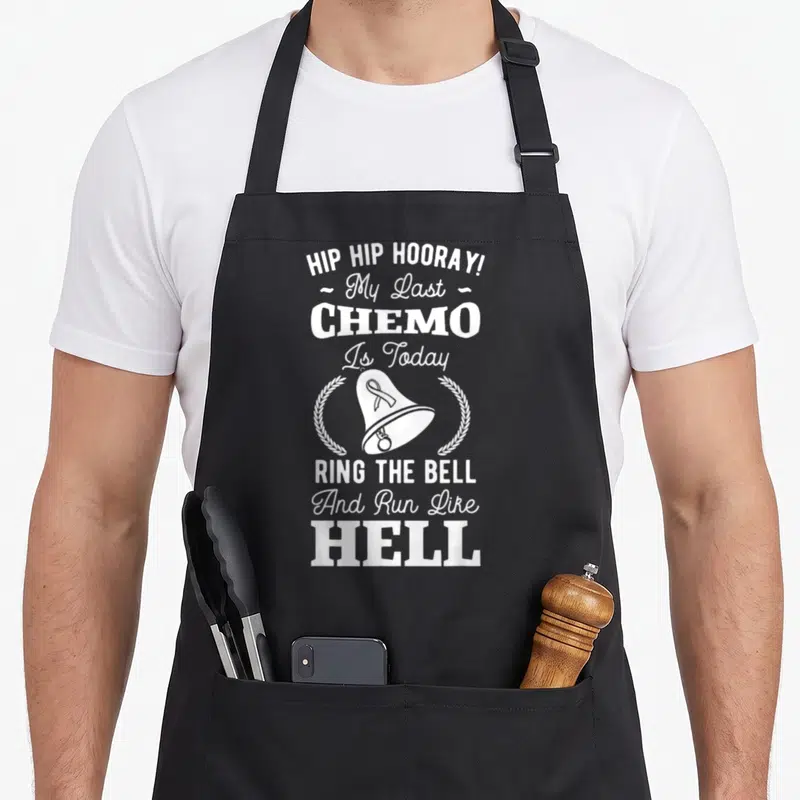 Chemo hip apron - White stacked text reading My Last Chemo Is Today with a bell and two wreaths — shown on a black cotton canvas apron against a white background