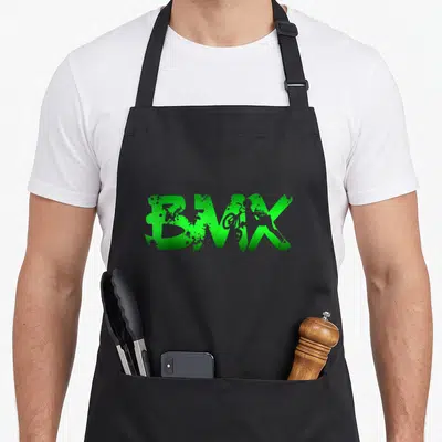 Distressed bike apron - Green distressed BMX text with rider silhouette inside letters — shown on a black cotton canvas apron against a white background