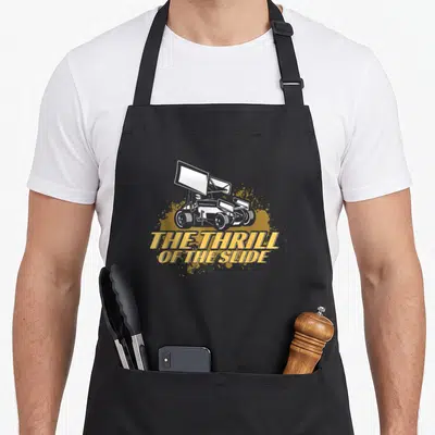 Thrill car apron - White sprint car over yellow splatter with text THE THRILL OF THE SLIDE — shown on a black cotton canvas apron against a white background