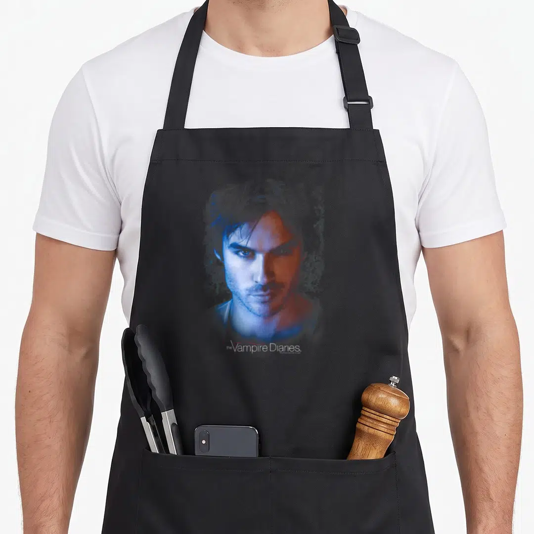 Damon vampire apron - Stylized blue and red portrait of a man with Vampire Diaries text below — shown on a black cotton canvas apron against a white background