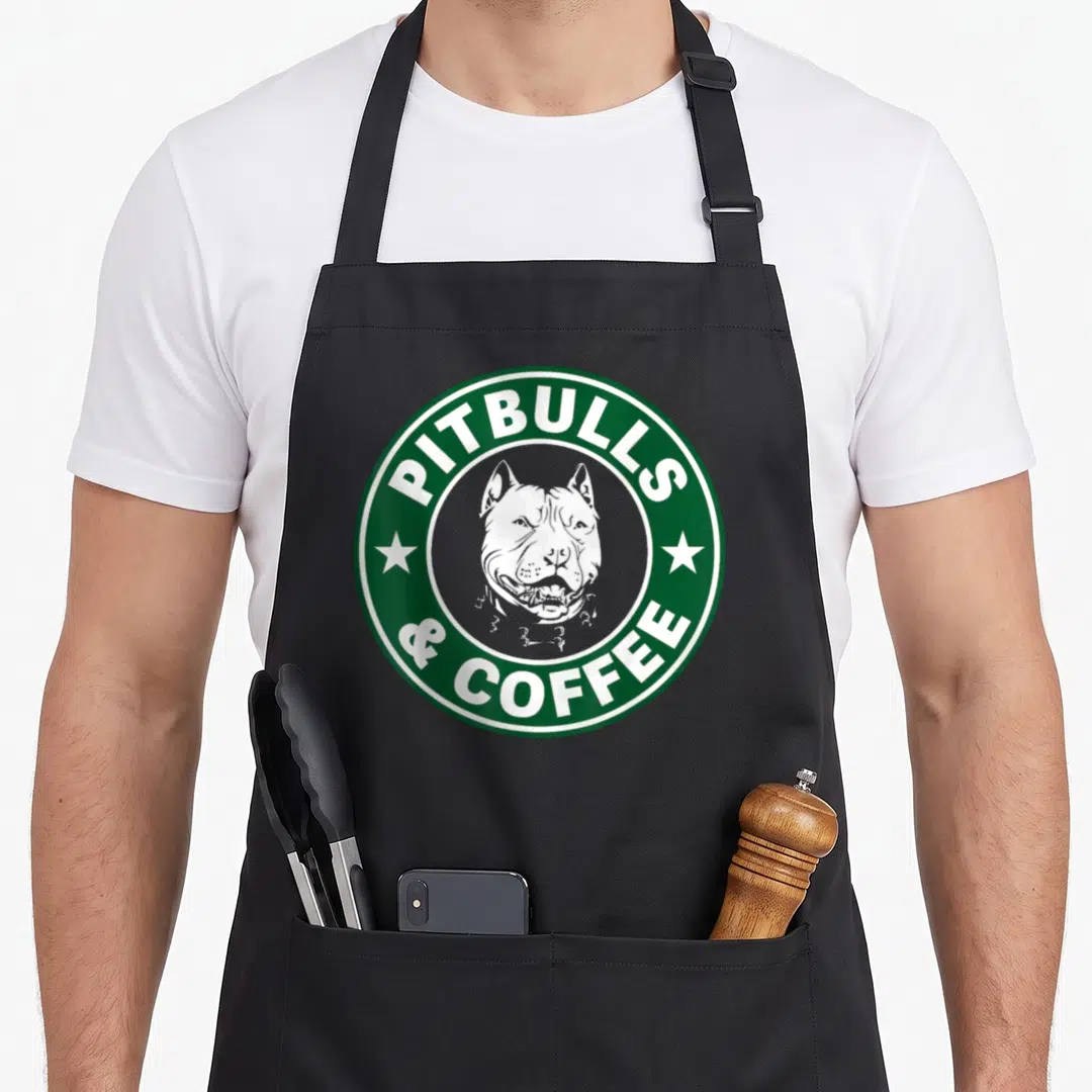 Pitbull coffee apron - Green circular logo with white pitbull head and text PITBULLS & COFFEE separated by stars — shown on a black cotton canvas apron against a white background
