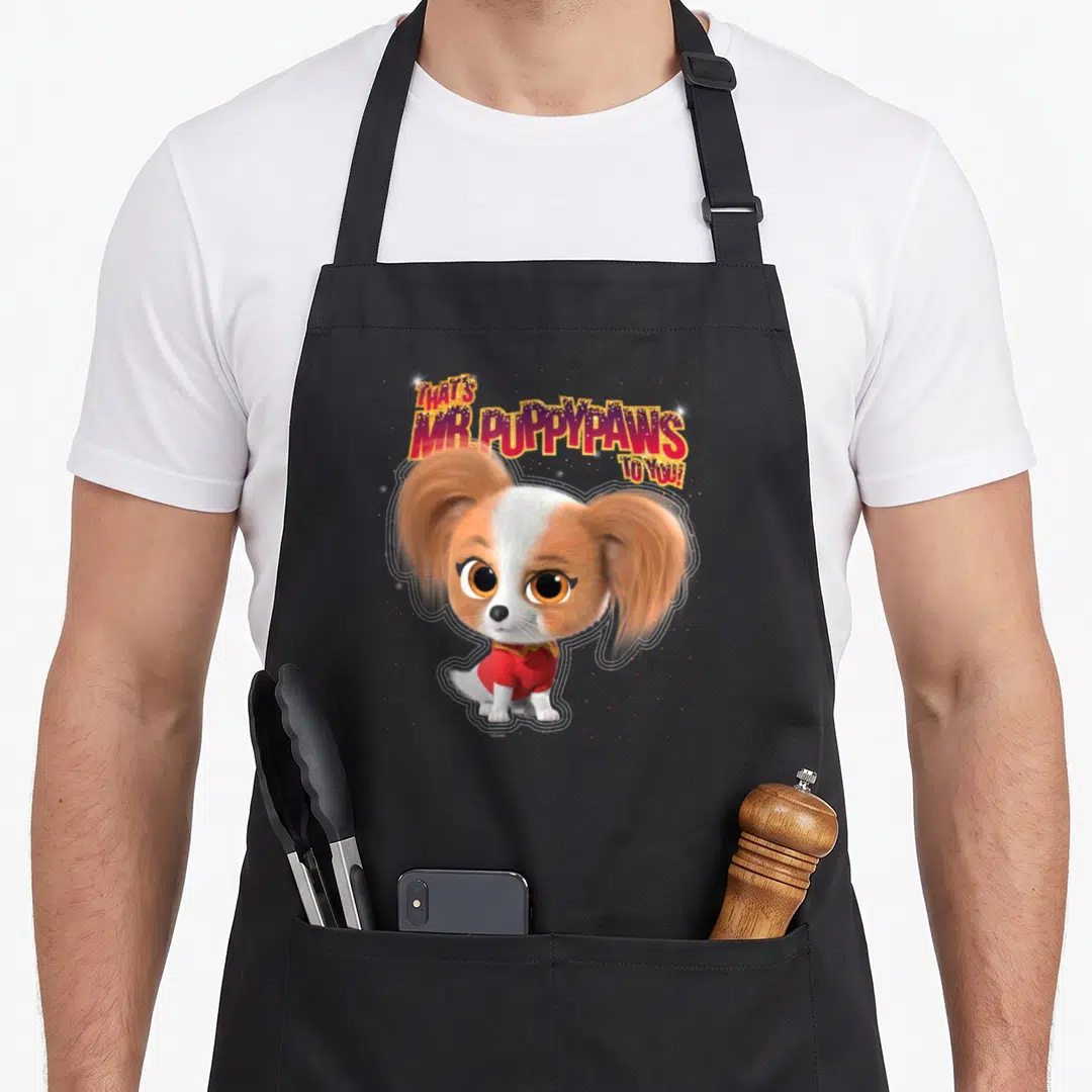 Puppypaw junior apron - Arched text That's Mr. Puppypaws To You above a white and brown dog in a red sweater surrounded — shown on a black cotton canvas apron against a white background