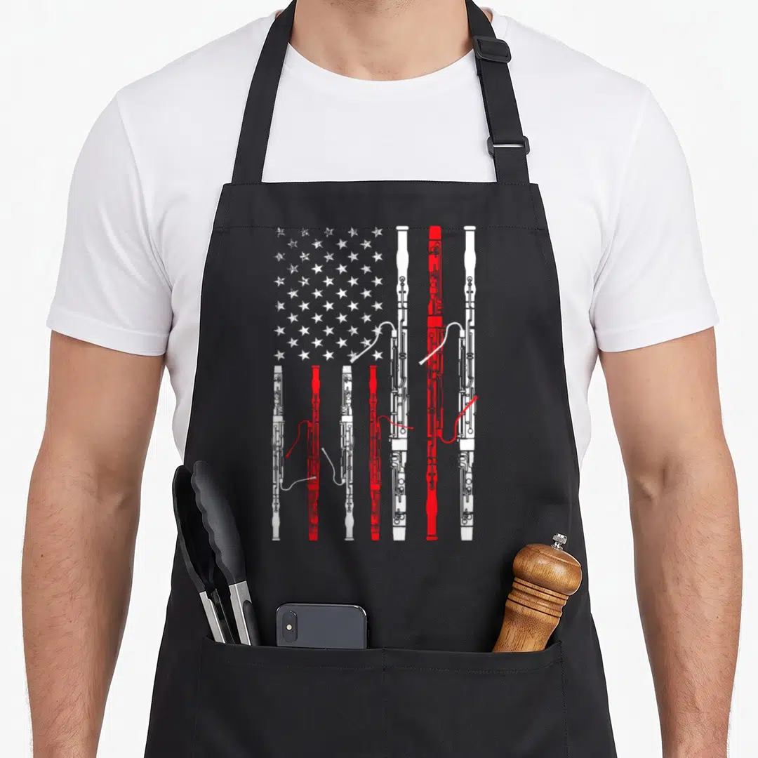 Bassoon 4th of july apron - Vertical oboes in white and red forming flag stripes with stars — shown on a black cotton canvas apron against a white background