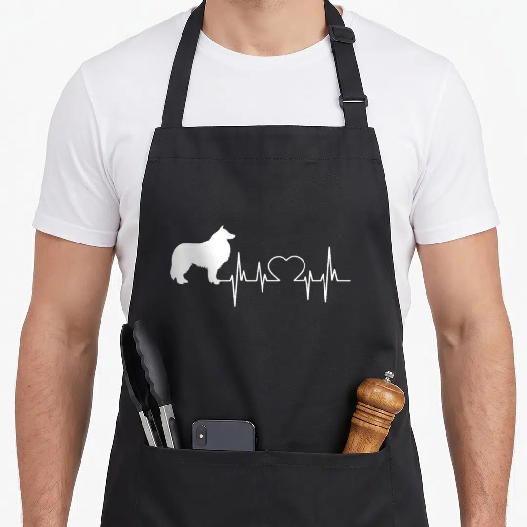 Scottish collie dog apron - White silhouette of a collie connected to a heartbeat line with a heart shape — shown on a black cotton canvas apron against a white background