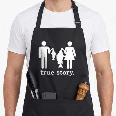 Story fishing fish apron - White stick figures holding fish of different sizes with text true story below — shown on a black cotton canvas apron against a white background