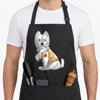 Tattoo westie apron - Cartoon Westie in tan bone shirt with red heart tattoo saying I LOVE MOM — shown on a black cotton canvas apron against a white background