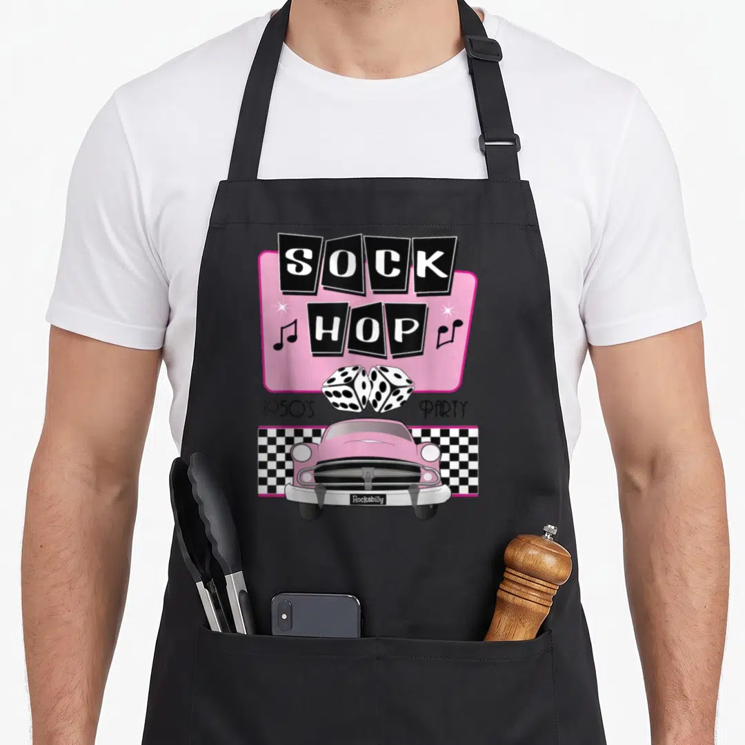 50s rockabilly apron - Pink car dice sock hop 1950s party text art — shown on a black cotton canvas apron against a white background