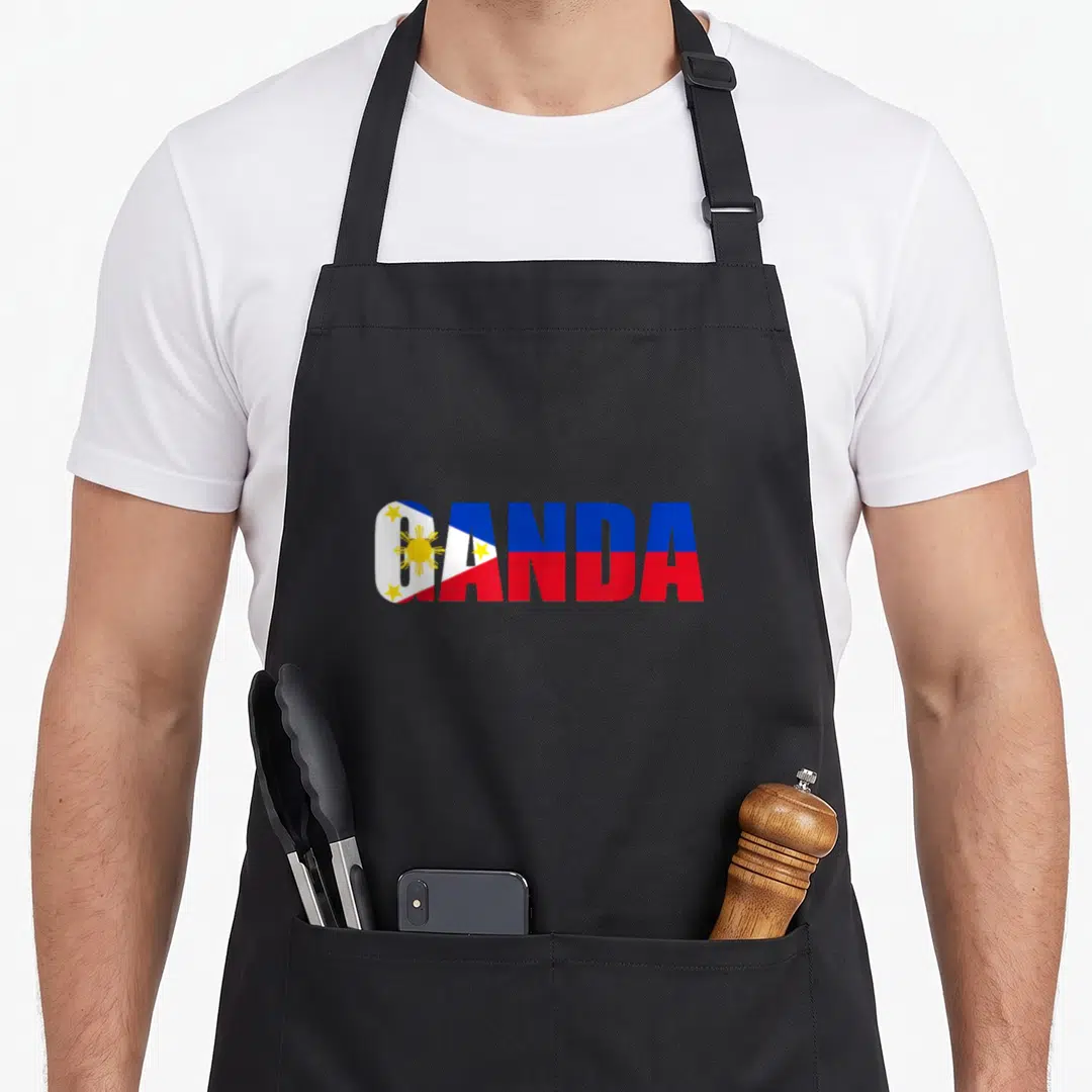 Filipina filipino american apron - GANDA text filled with Philippine flag sun, stars, and blue red white yellow stripes — shown on a black cotton canvas apron against a white background