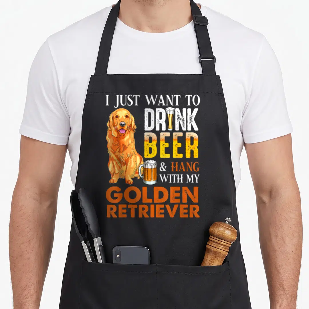 Drink golden retriever apron - Cartoon golden retriever sitting next to stacked text about drinking beer and hanging — shown on a black cotton canvas apron against a white background