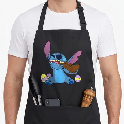 Stitch easter egg apron - Blue cartoon character biting brown bunny with yellow and purple eggs — shown on a black cotton canvas apron against a white background