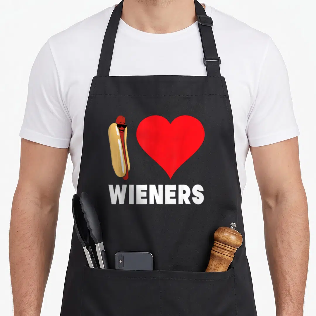 Lgbt wiener apron - Cartoon hot dog in sunglasses next to red heart with white text — shown on a black cotton canvas apron against a white background
