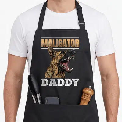 Belgian dog breed aprons - Realistic tan and brown dog head with open mouth flanked by Maligator and Daddy text — shown on a black cotton canvas apron against a white background