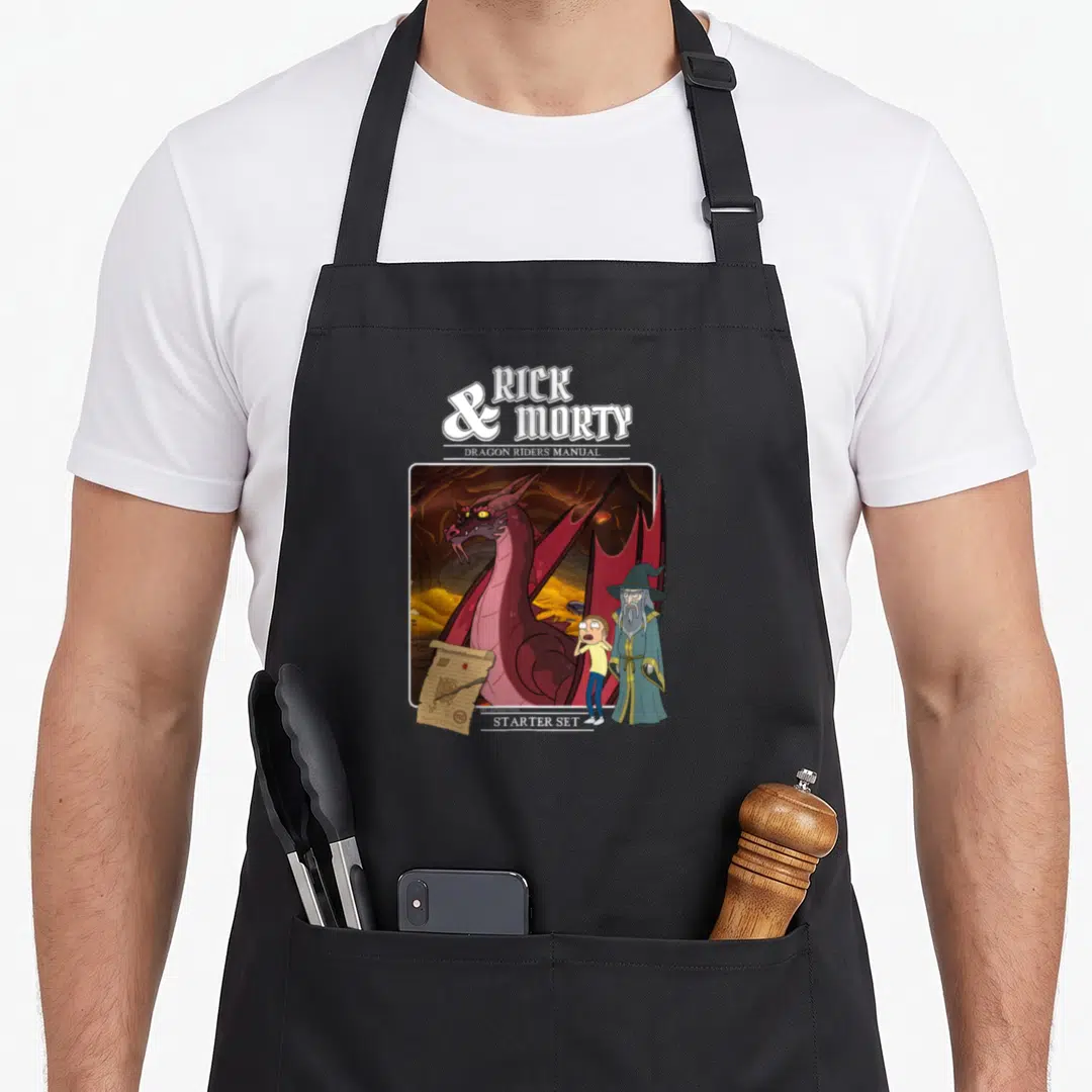 Role cartoon apron - Rick and Morty Dragon Riders Manual Starter Set with dragon illustration and scroll — shown on a black cotton canvas apron against a white background