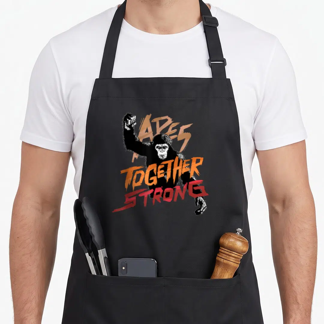Rise ape apron - Black chimpanzee with distressed orange and red TOGETHER STRONG text overlay — shown on a black cotton canvas apron against a white background